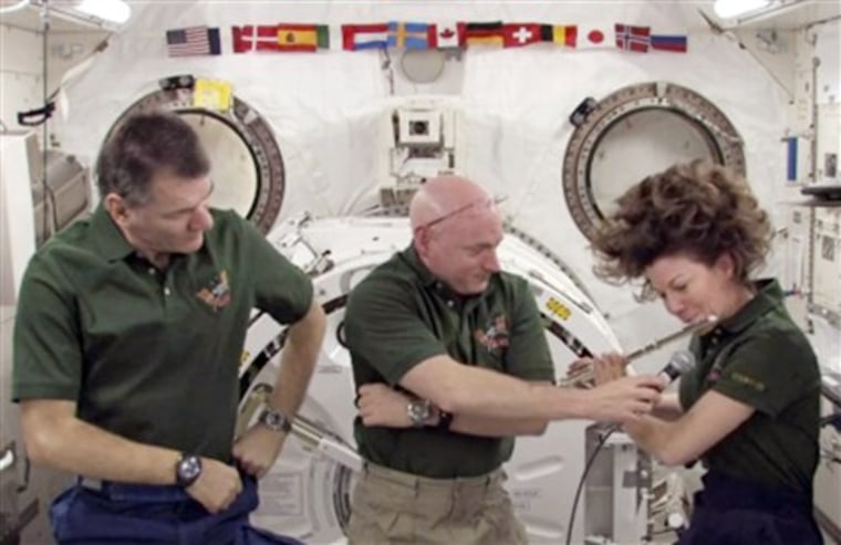 In this frame grab from video shot on Wednesday and made available by NASA, astronaut Scott Kelly holds a microphone for astronaut Catherine Coleman, right, while she plays the flute aboard the International Space Station. She's got four flutes with her: one is her own, two belong to members of the Irish group The Chieftains and one belongs to Ian Anderson, flutist for Jethro Tull. 